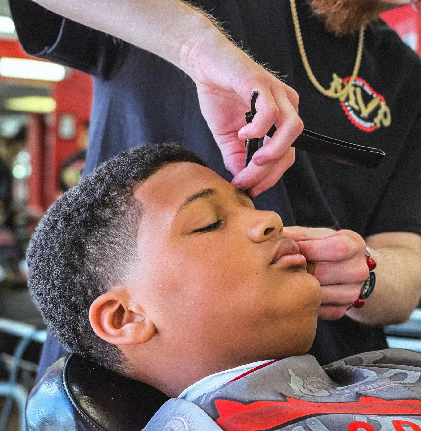 MVP barber carefully shaping a customer's hairline