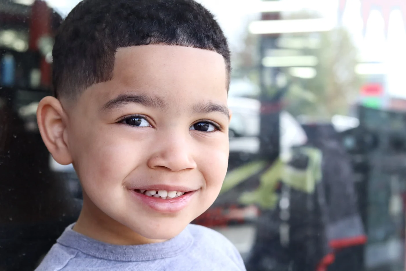 A smiling young customer showing his finished haircut